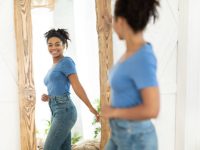 Successful Weight Loss. Joyful African American Girl After Slimming Smiling To Her Reflection In Mirror Standing At Home. Staying Fit, Dieting And Weight-Loss Concept. Selective Focus